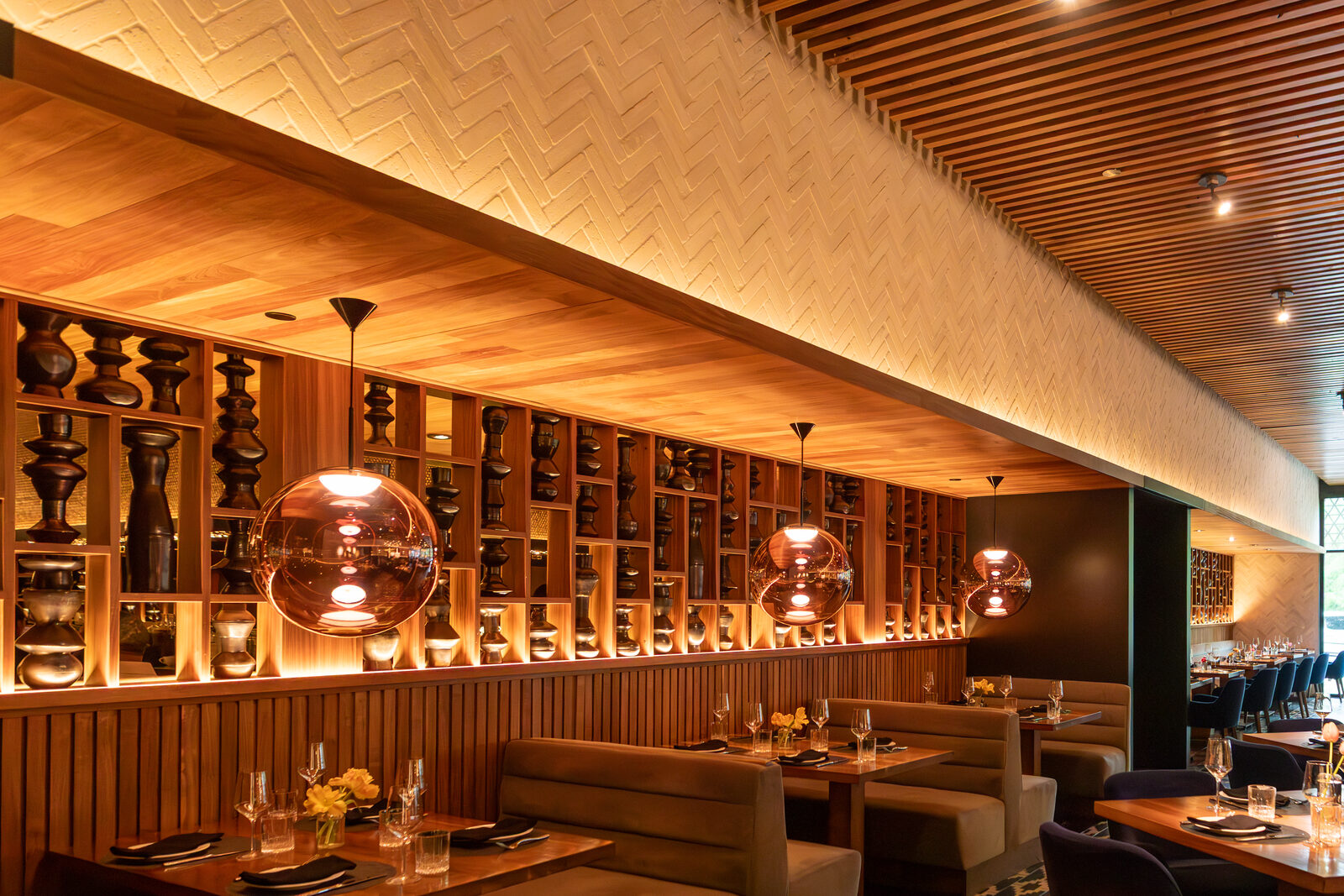 Warmly lit restaurant interior with globe pendant lights and upholstered booths