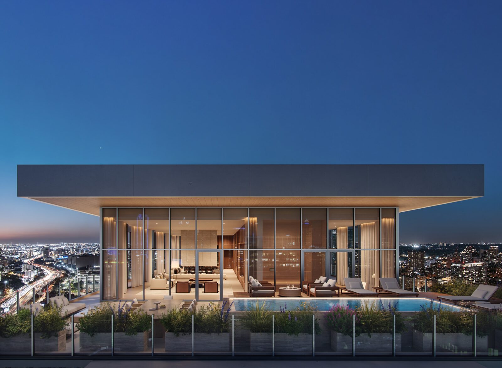 Glass pavilion of The Penthouse illuminated above Dallas at dusk